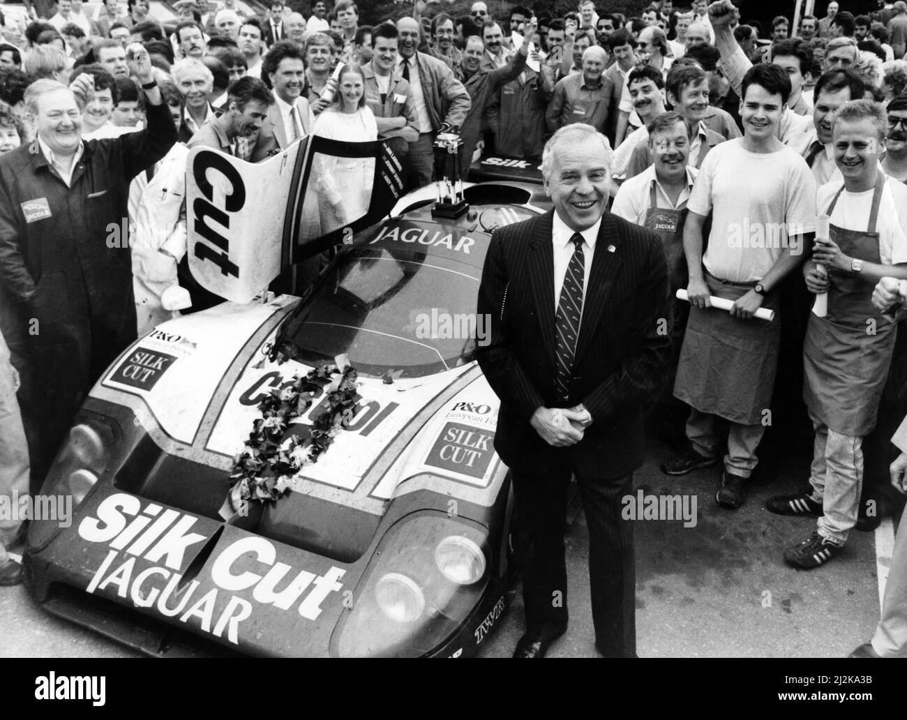 Der Geschäftsführer von Jaguar Cars, Sir John Egan, mit dem Fahrzeug, das das 24-Stunden-Rennen von Le Mans gewann. 15.. Juni 1988. Stockfoto