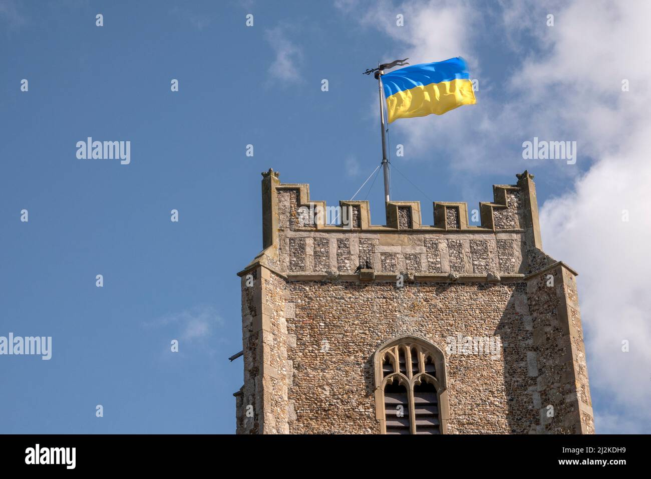 Die zweifarbige Flagge der Ukrainischen Volksrepublik, die vom Kirchturm von St. Peter und St. Paul's, Aldeburgh, Suffolk, weht. Bei strahlendem Sonnenschein. Stockfoto