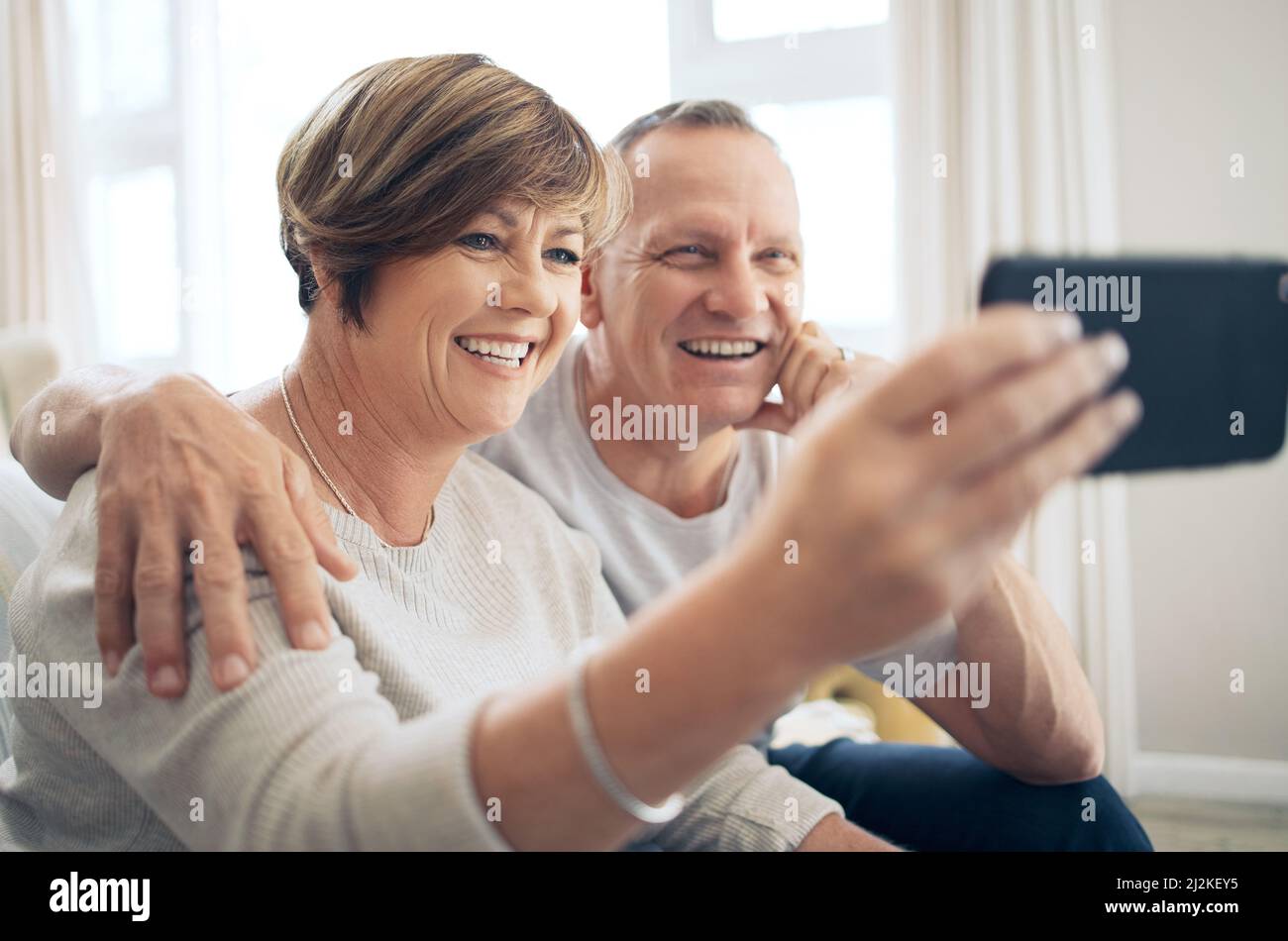 Dein Lächeln erhellt meine Welt. Aufnahme eines reifen Paares, das Selfies macht. Stockfoto