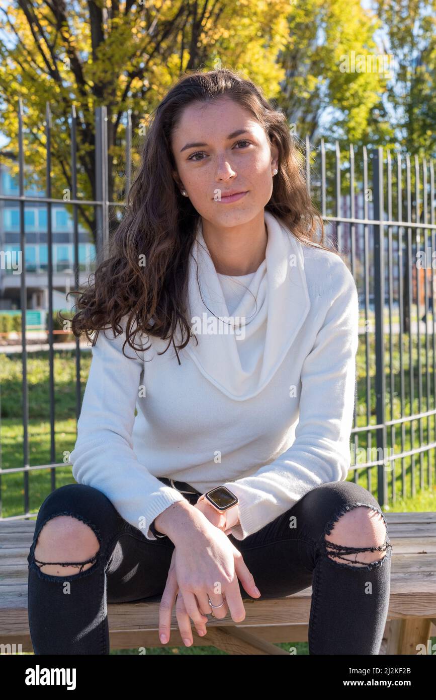 Junge Frau, die für ein Porträt posiert, vertikales Porträt einer schönen tausendjährigen Frau Stockfoto