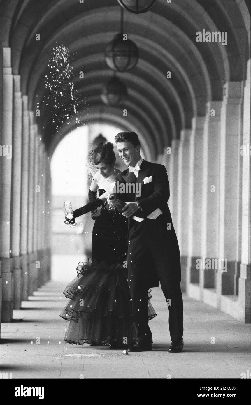 Zwei Darlinge des deb-Sets geben einen Toast auf die Mode, als sie sich auf eine Nacht voller Ballkleider und Sekt auf der Charity Berkeley Dress Show vorbereiteten.Victoria Sykes und Adam Parson wurden von 21other hellen jungen Dingen begleitet, die im Savoy Lancaster Ballroom Kleidung modellierten. Alle Einnahmen aus der Veranstaltung wurden an den NSPCC gespendet. 13.. April 1987 Stockfoto