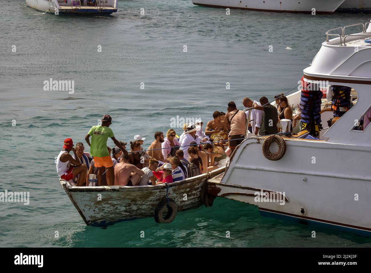 Ausschiffung von Menschen von Yacht zu Motorboot. Touristen auf Yacht und Motorboot fahren. Aktive Erholung am Roten Meer, Resort, Urlaub und Abenteuer, Stockfoto
