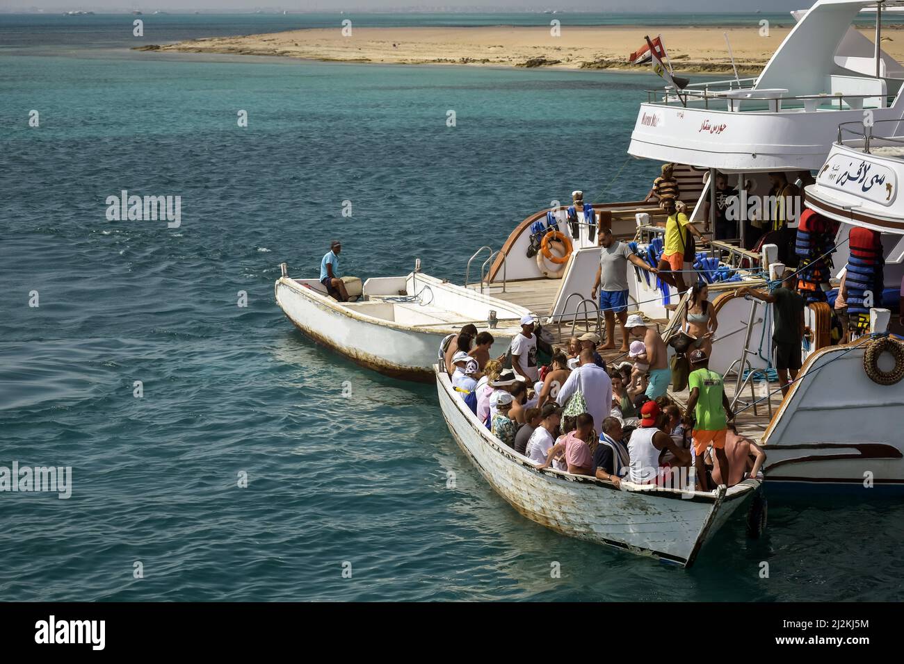 Ausschiffung von Menschen von Yacht zu Motorboot. Touristen auf Yacht und Motorboot fahren. Aktive Erholung am Roten Meer, Resort, Urlaub und Abenteuer, Stockfoto