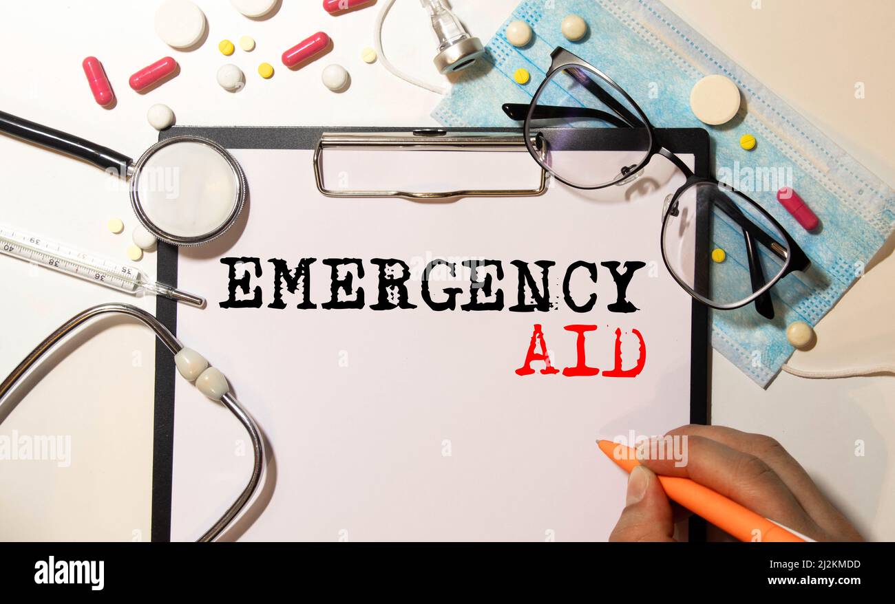 Nahaufnahme eines erste-Hilfe-Handbuchs mit schwarzer Brille auf der Oberseite. Was ist in einem Notfall-Unfall-Szenario zu tun? Stockfoto