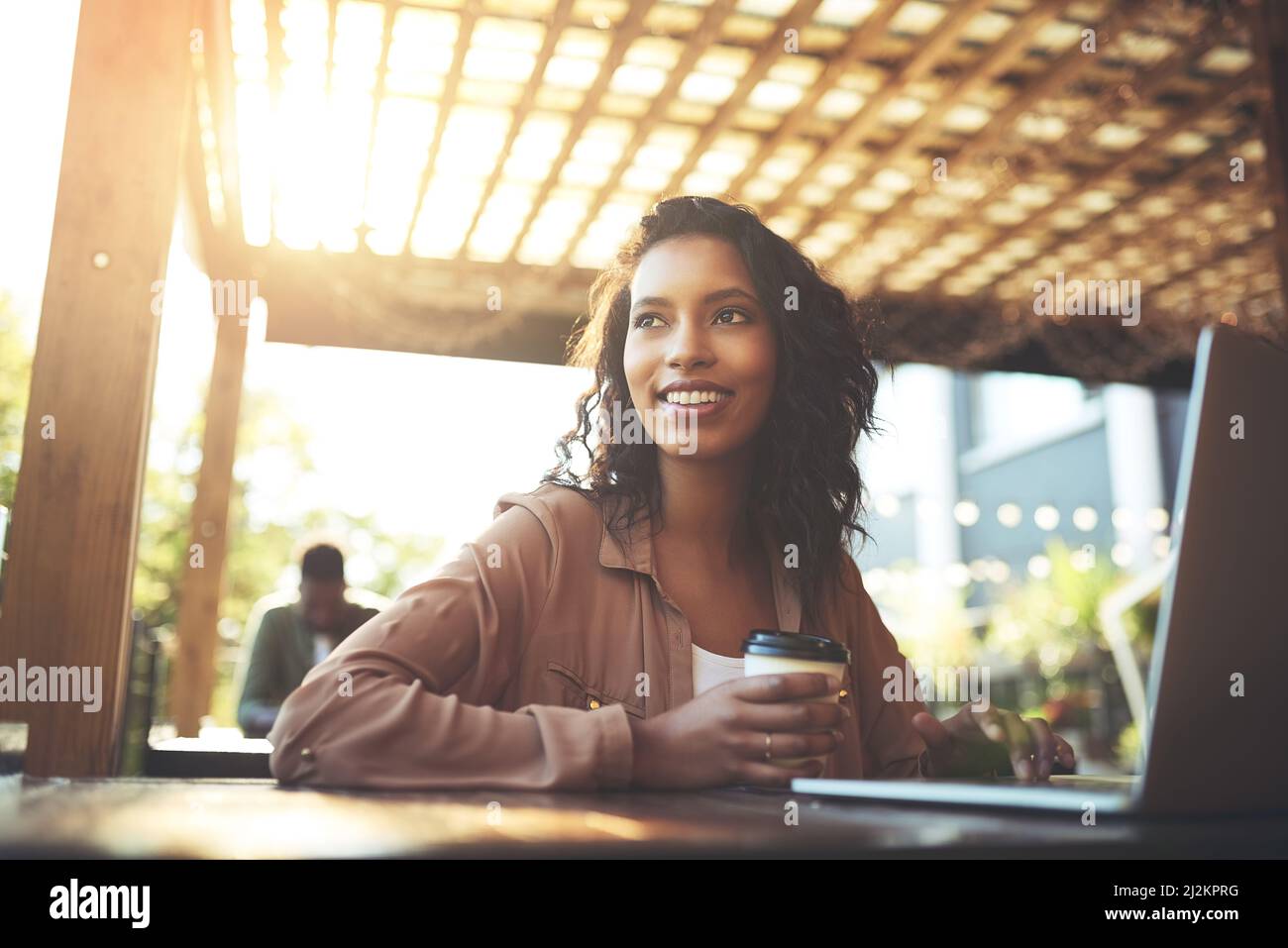 Ich kann mich über dieses Hotel überhaupt nicht beschweren. Eine kleine Aufnahme einer jungen Frau, die in einem Café einen Laptop benutzt. Stockfoto