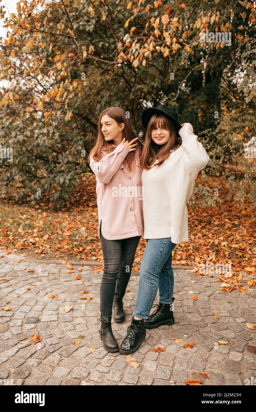 Vertikale beste Freunde, Frauen bleiben goldene herbstliche Parklandschaft Steinstraße, jjoying, zu Fuß in der Nähe von grünen Orangenbäumen Stockfoto