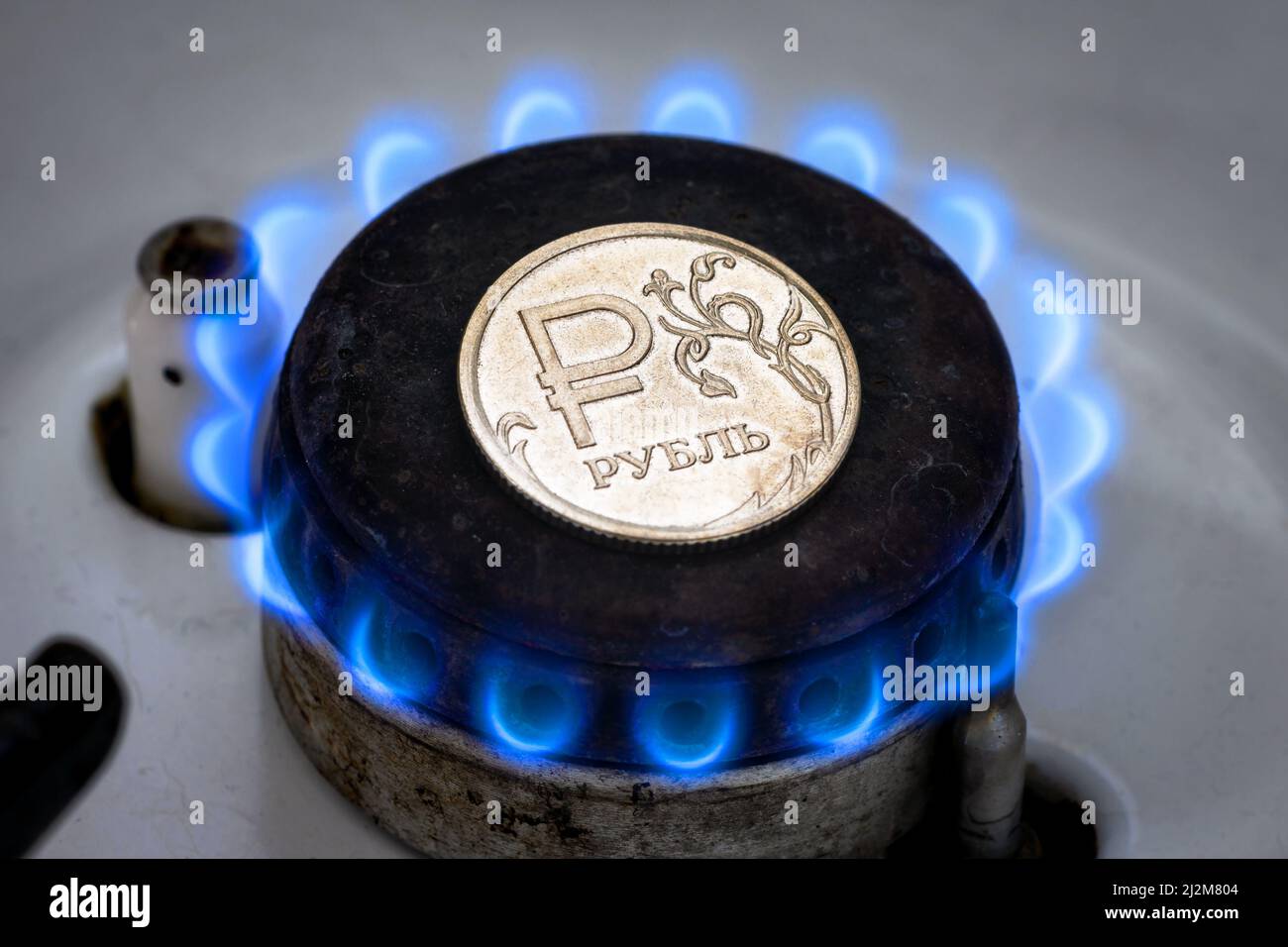 Gasbrenner und Rubel-Münze, russisches Geld auf heimigem Gasherd. Natürliche Propangasflamme und Rubel Währung. Konzept der russischen und europäischen Wirtschaft, Gas CO Stockfoto