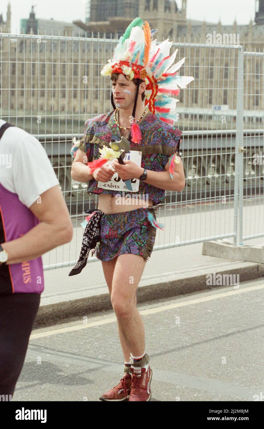 Der London Marathon - 1991Runners in ausgefallener Kleidung über Westminster Bridge, Central London. Ein Läufer Kleid wie ein Red Indian. Lauf Funnies. Bild aufgenommen am 21.. April 1991 Stockfoto