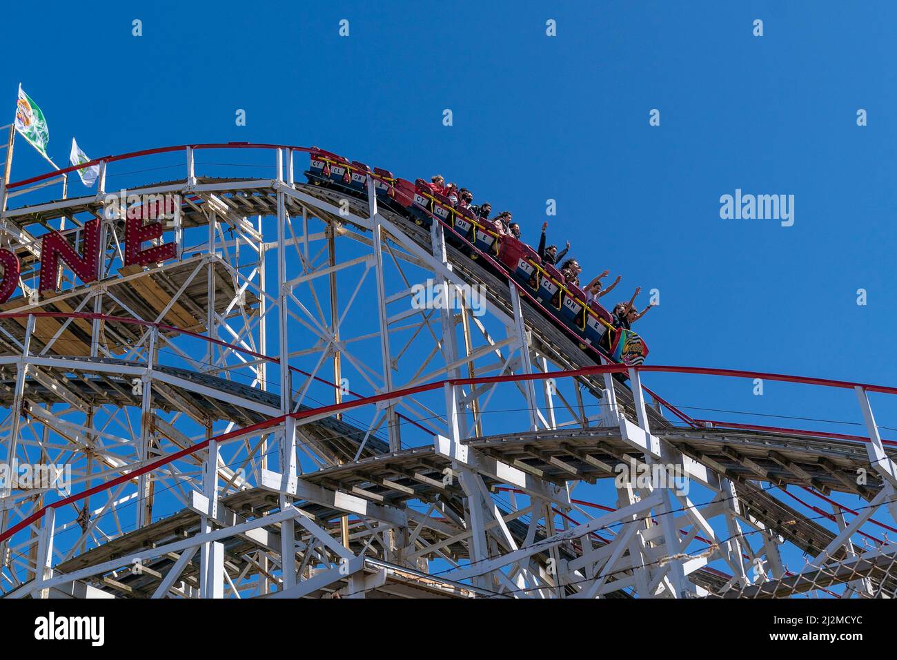 New York, USA. 02. April 2022. Besucher fahren während der Saisoneröffnung des Luna Park auf Coney Island in New York am 2. April 2022 mit der Achterbahn Coney Island Cyclone. Die Eröffnung des Luna Parks wurde von lokalen Politikern besucht, die Fahrten des Parks ziehen Tausende von Menschen aus allen fünf Bezirken und darüber hinaus an. 2022 ist das Betriebsjahr 95. für den Park. (Foto von Lev Radin/Sipa USA) Quelle: SIPA USA/Alamy Live News Stockfoto