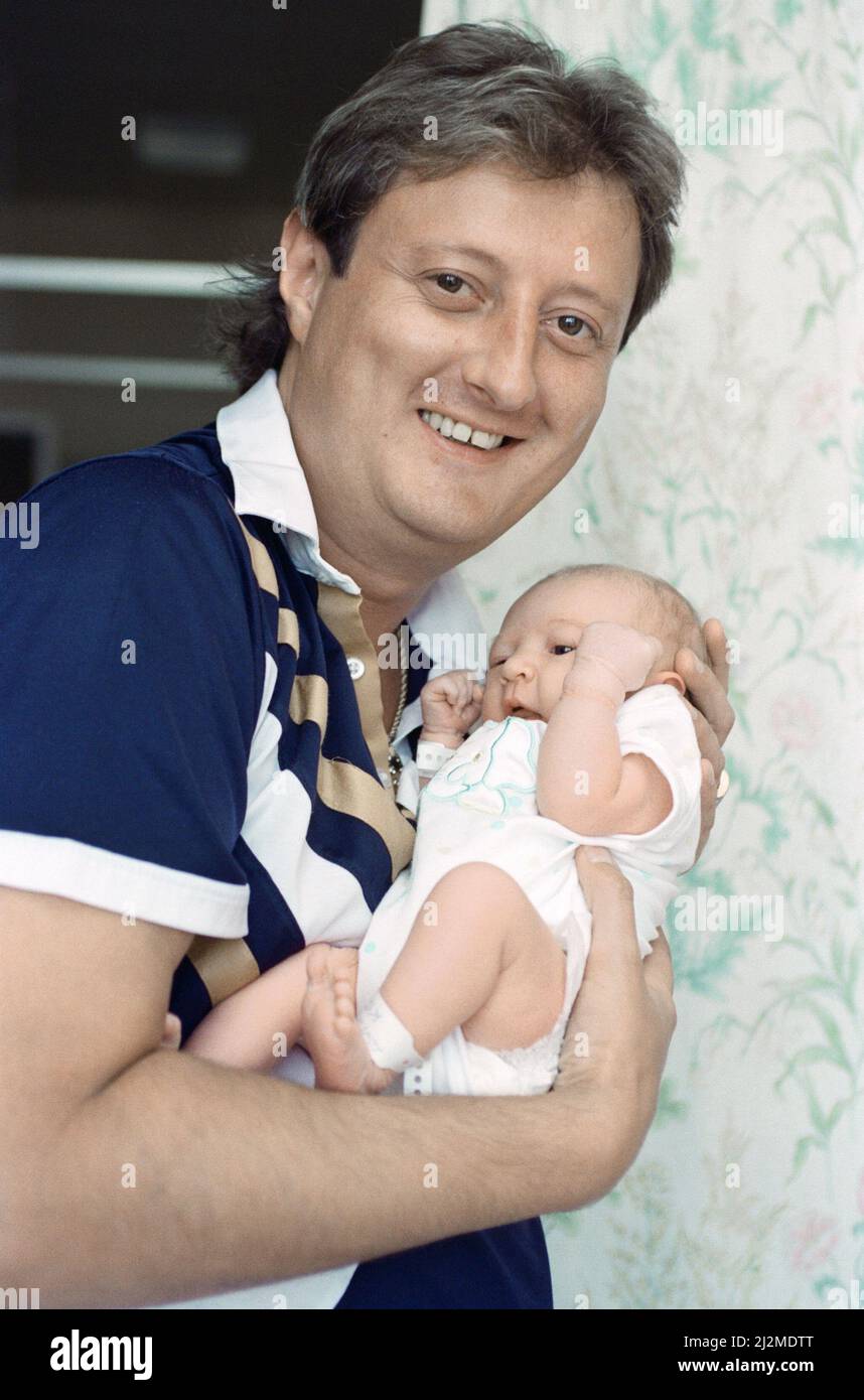 Der britische Darts-Spieler Eric Bristow posiert zu Hause mit seinem neugeborenen Mädchen namens Louise. 29.. August 1991. Stockfoto