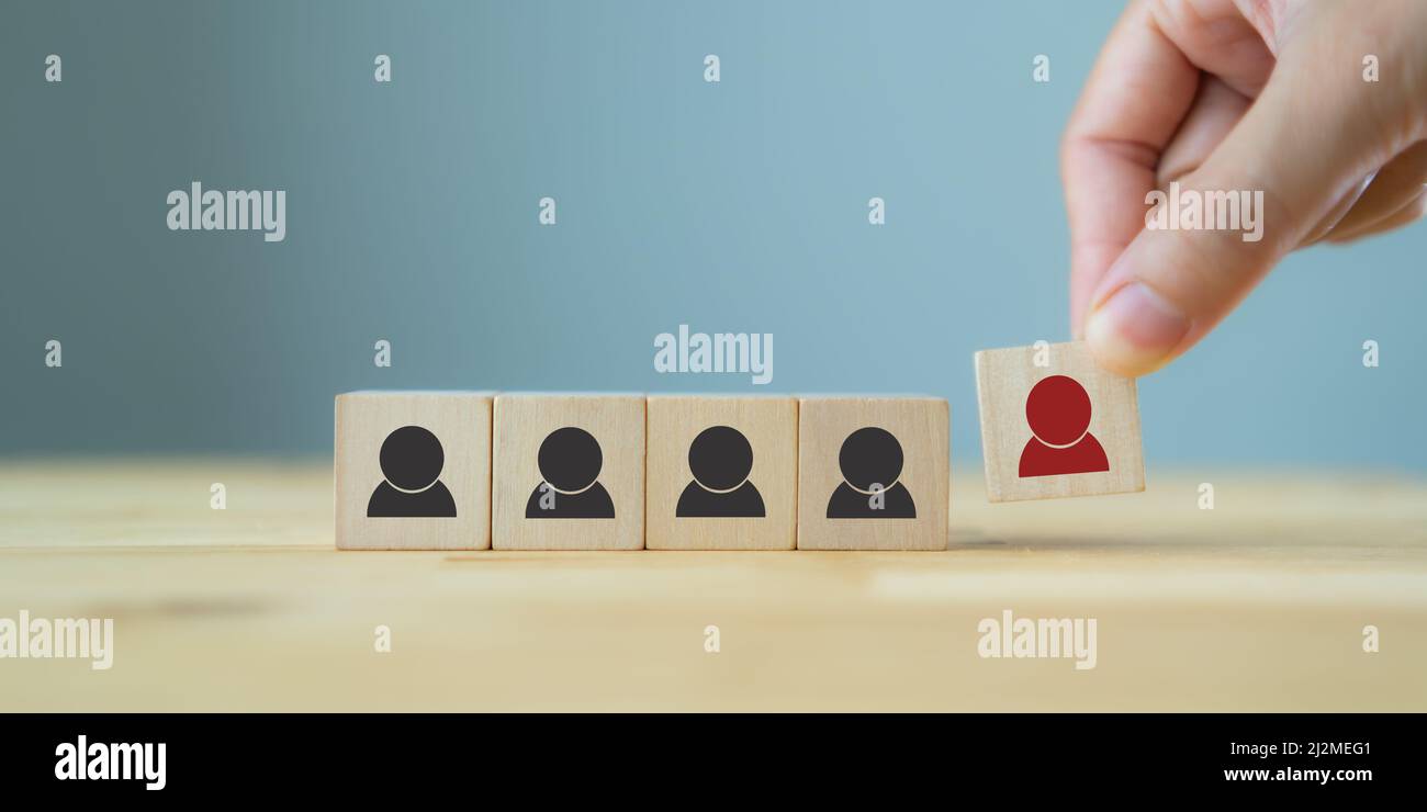 Personalmanagement, Rekrutierung und Zielkundengeschäft. Die Hand des Mannes setzt eine rote Person aus Holzwürfel, die auf der Menge mit Schwarz steht Stockfoto