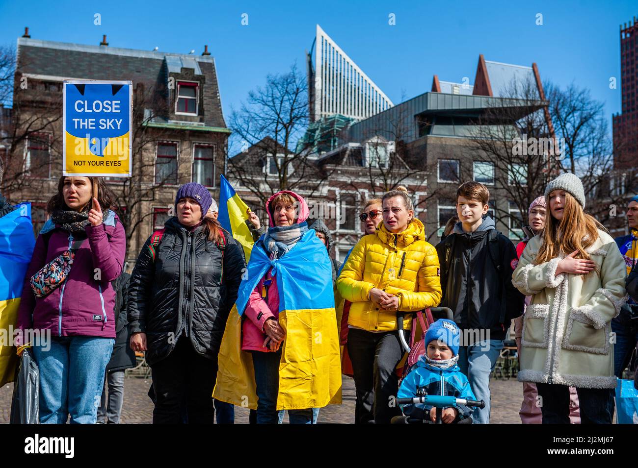 Den Haag, Niederlande. 02. April 2022. Eine Gruppe ukrainischer Menschen singt während der Demonstration die Nationalhymne. Vor dem Repräsentantenhaus der Niederlande wurde eine ukrainische Kunstinstallation aufgestellt, um die Aufmerksamkeit der niederländischen Behörden und der Bevölkerung auf die Tötungen von Zivilisten und insbesondere von Kindern während des Krieges in der Ukraine zu lenken. (Foto: Ana Fernandez/SOPA Images/Sipa USA) Quelle: SIPA USA/Alamy Live News Stockfoto