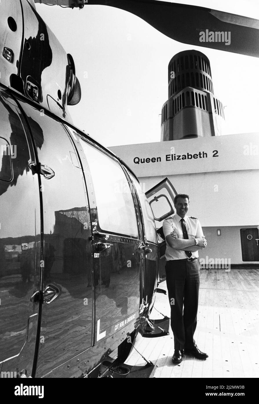 Queen Elizabeth 2, Ozeandampfer, gebaut für die Cunard Line, die von Cunard sowohl als transatlantischer Linienschiff als auch als Kreuzschiff von 1969 bis 2008 betrieben wurde. Im Bild: Hubschrauberpilot, Kapitän David Warren an Bord der QE2 während eines Besuchs in Liverpool, Merseyside. 24.. Juli 1990. Stockfoto