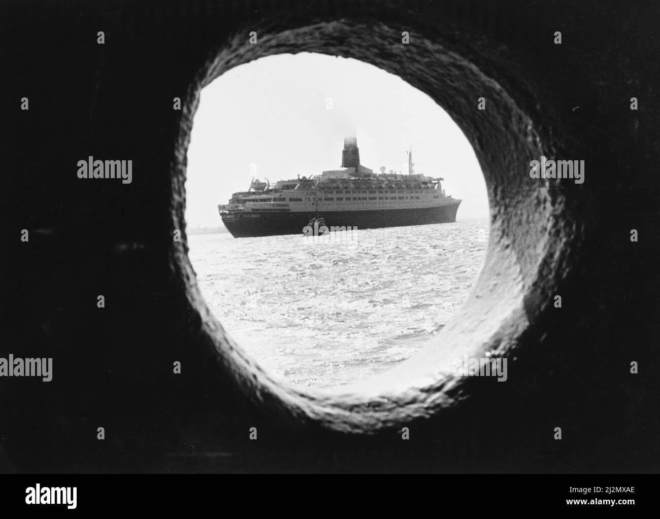 Queen Elizabeth 2, Ozeandampfer, gebaut für die Cunard Line, die von Cunard sowohl als transatlantischer Linienschiff als auch als Kreuzschiff von 1969 bis 2008 betrieben wurde. Abgebildet. Die QE2 vom Bullauge Royal Iris (Mersey Ferry) aus gesehen. 24.. Juli 1990. Stockfoto