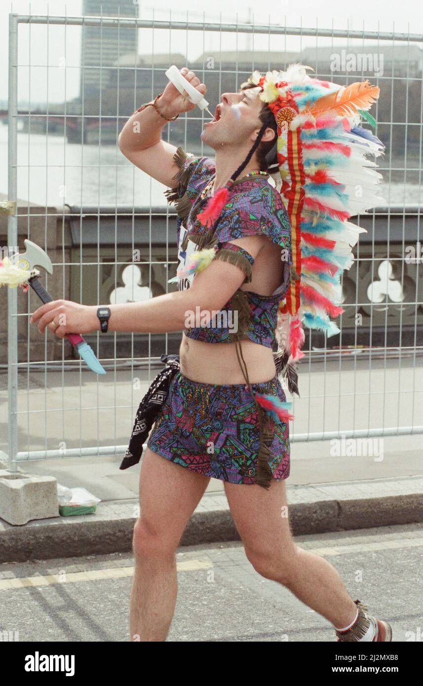 Der London Marathon - 1991Runners in ausgefallener Kleidung über Westminster Bridge, Central London. Ein Läufer Kleid wie ein Red Indian. Lauf Funnies. Bild aufgenommen am 21.. April 1991 Stockfoto