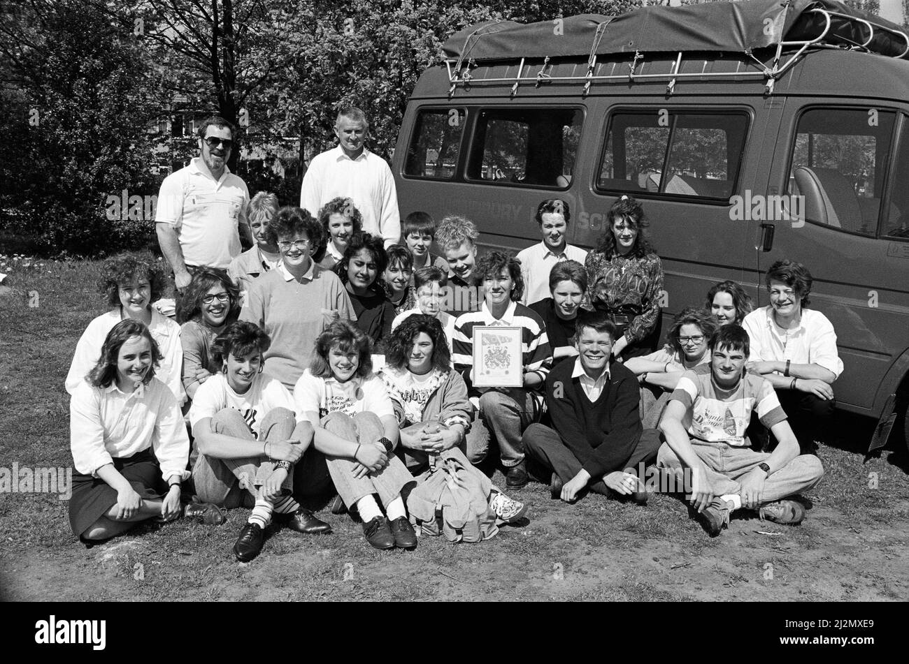 Eine Gruppe von Schülern aus Deutschland besuchte die Almondbury High School im Rahmen eines Austauschbesuchs. Die Gruppe von 15 Studenten im Alter von 13 bis 15 Jahren aus Siegen im vergangenen Jahr. Die Gruppe wurde vom Bürgermeister von Kirklees, Clr Colin Watson, begrüßt und mit einer gerahmten Kopie des Kirklees-Wappens überreicht. Neben¿ dem neuen Mini-Bus der Schule, der zum ersten Mal während der Reise verwendet wurde, ist die Lehrerin Frau Dorle Hoening (Mitte) mit dem Wappen und einigen deutschen Feiern abgebildet. 2. Mai 1990 Stockfoto