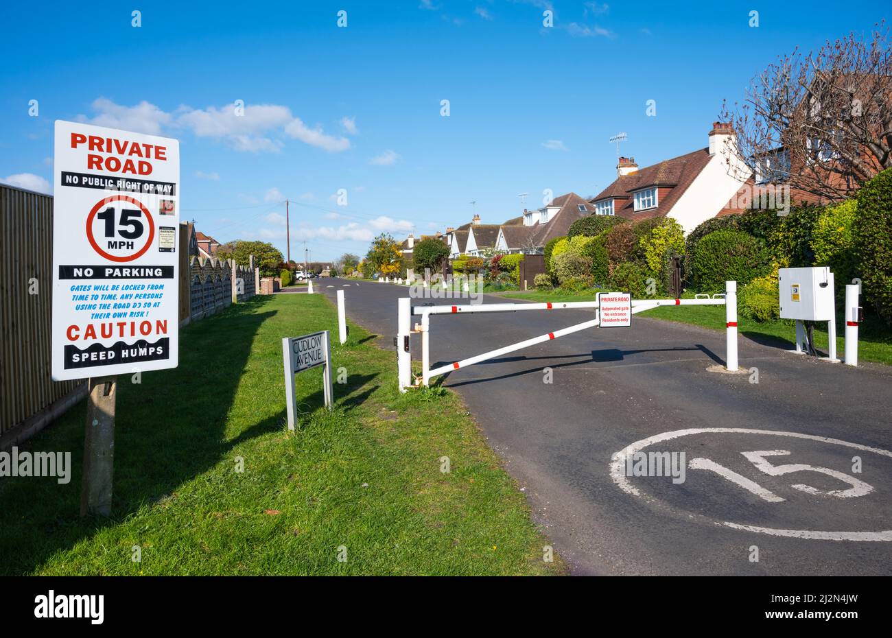 Eingezäunter Eingang mit geschlossenem Tor zu einer privaten Straße mit 15MPH Geschwindigkeitsbegrenzung an der Cudlow Avenue, Rustington, West Sussex, England, Großbritannien. Stockfoto
