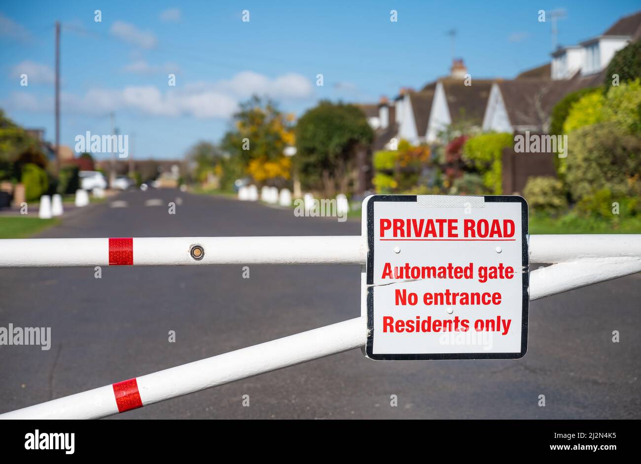 Eingezäunter Eingang mit geschlossenem Tor zu einer Privatstraße in der Cudlow Avenue, Rustington, West Sussex, England, Großbritannien. Stockfoto