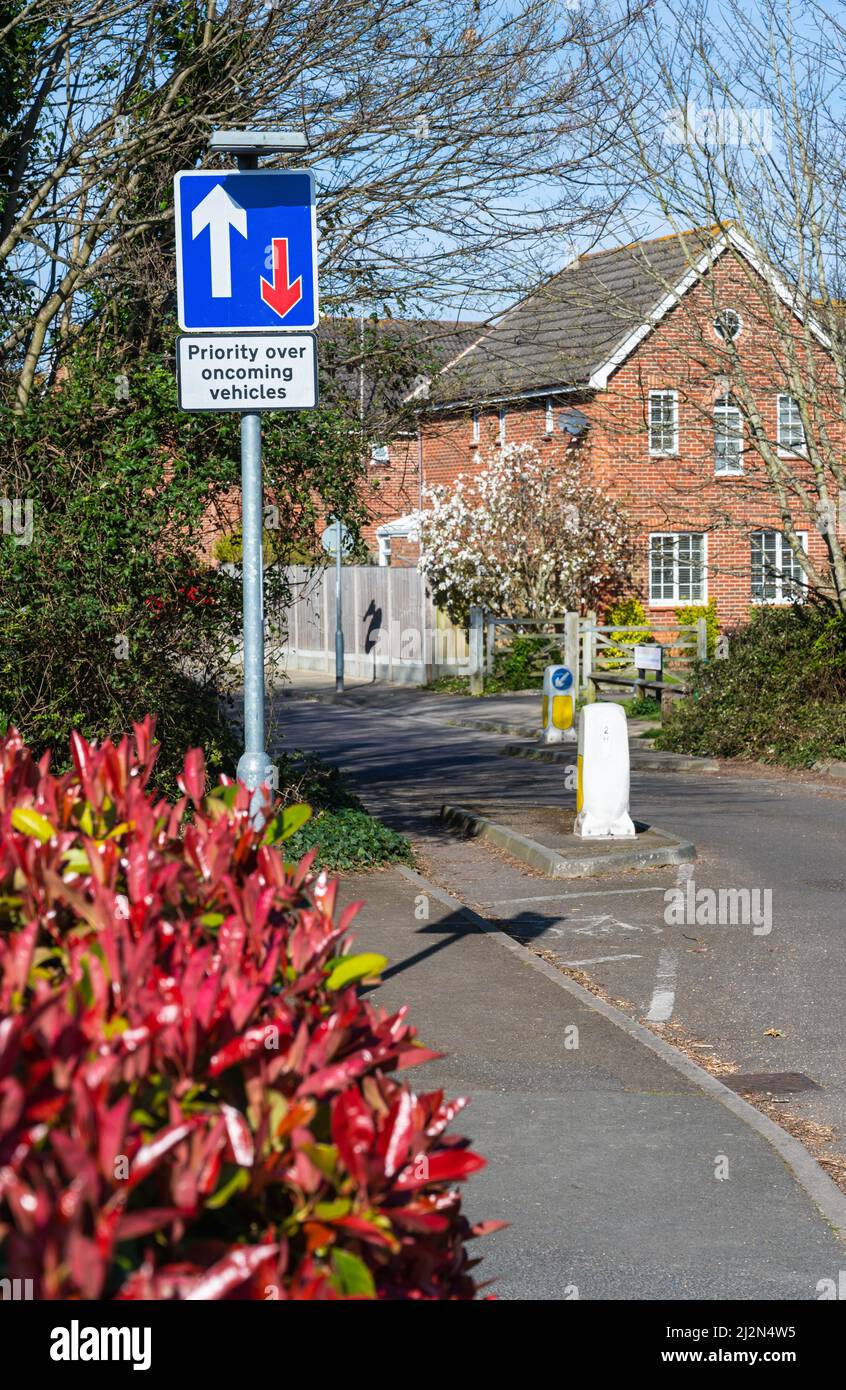Priorität vor entgegenkommenden Fahrzeugen Straßenschild, wo die Straße aufgrund von Maßnahmen zur Verkehrsberuhigung auf einer Straße in England, Großbritannien, enger wird. Stockfoto
