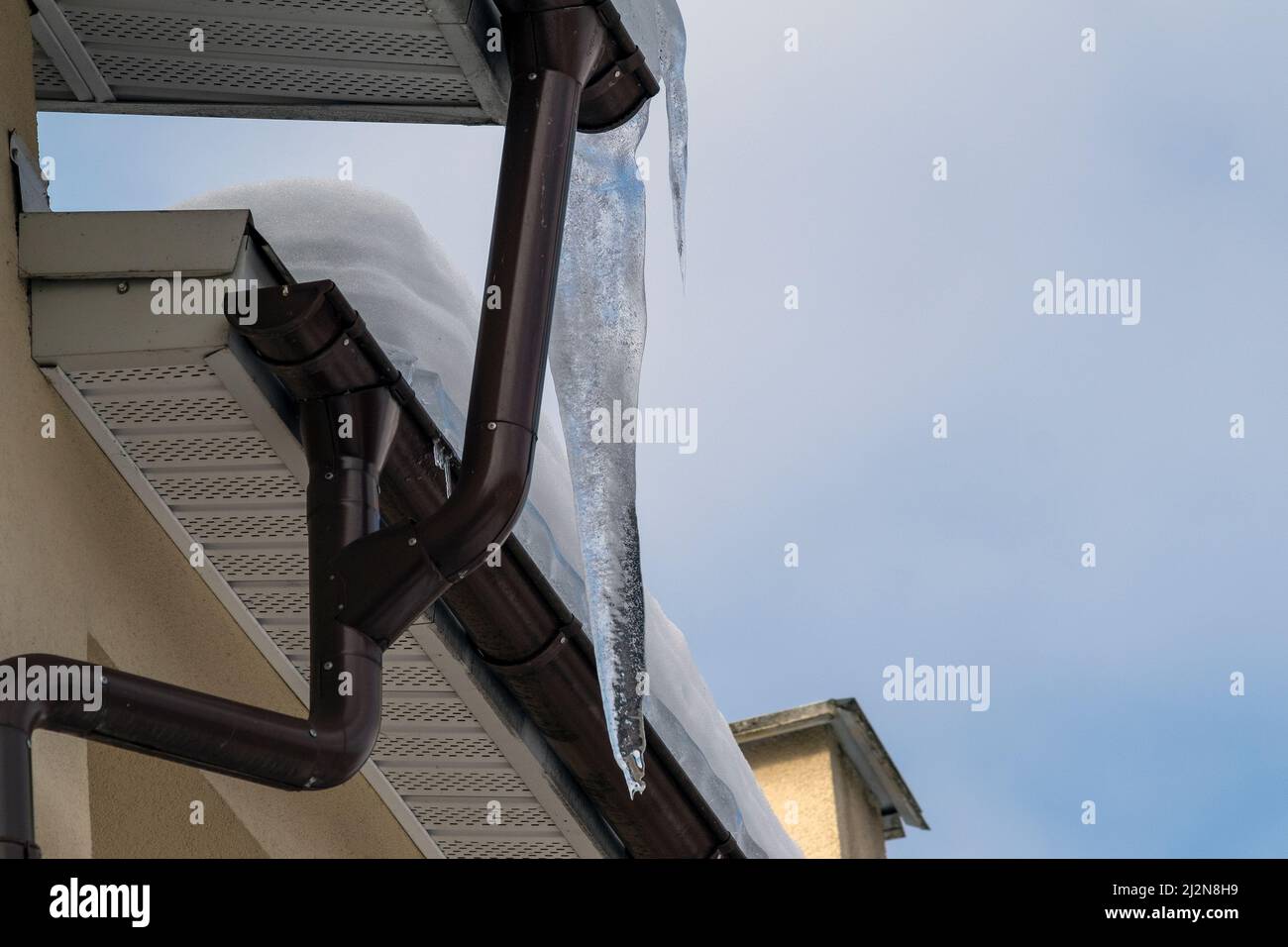 Ein riesiges Eiszapfen, das im Frühling auf einem Dach im Freien hängt Stockfoto