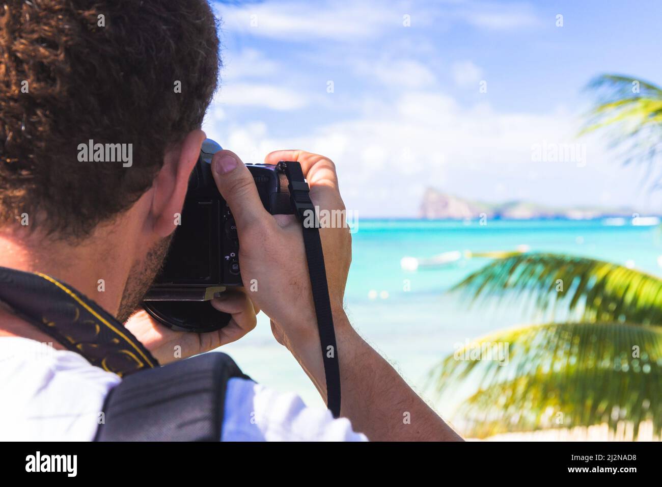 Mann hält die Kamera, die Aufnahme von Fotos von schöner Landschaft mit Meer, selektiver Fokus Stockfoto