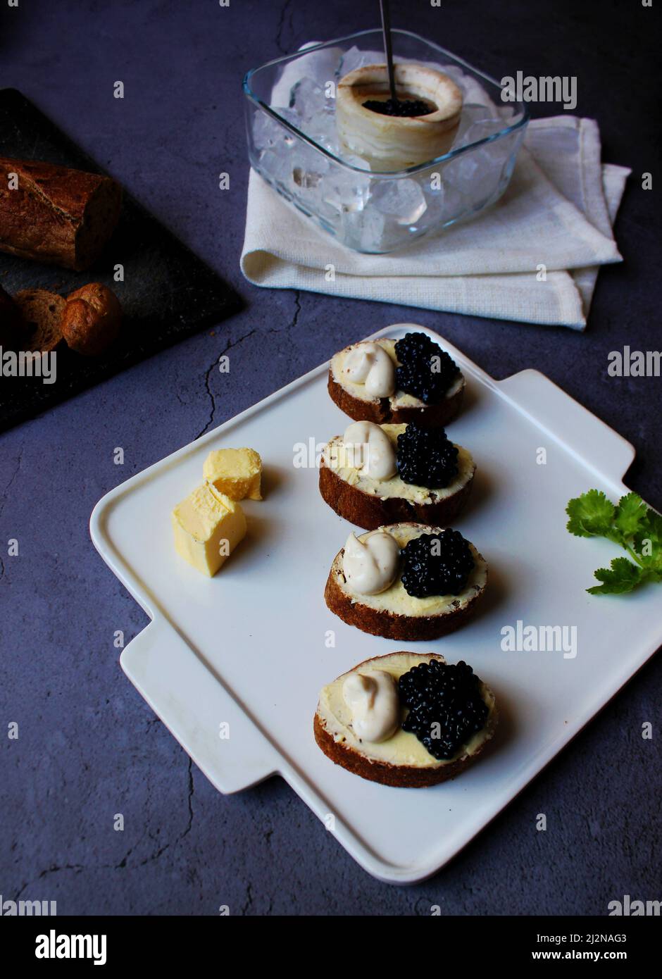 Schwarze Caviar Bruschetta auf weißem Teller, grauer Hintergrund. Stockfoto