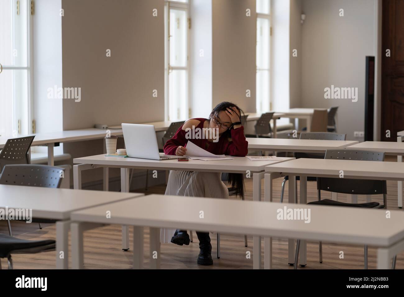 Asiatische Student Mädchen fühlen sich müde und unmotiviert, während das Studium in der Universitätsbibliothek Stockfoto