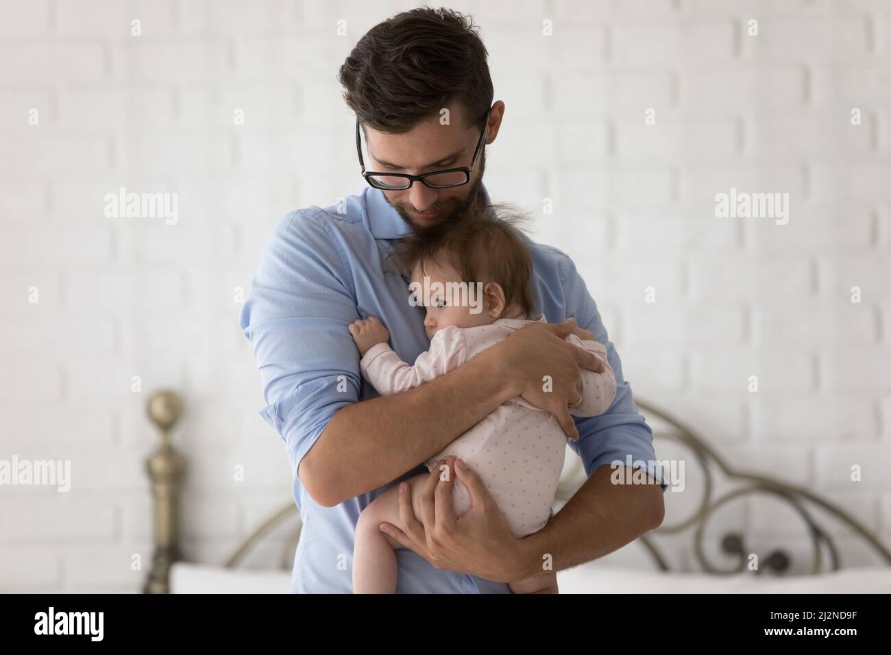 Fürsorglicher Vater hält schaukelnd, beruhigend liebenswert Baby, hält kleine Tochter Stockfoto