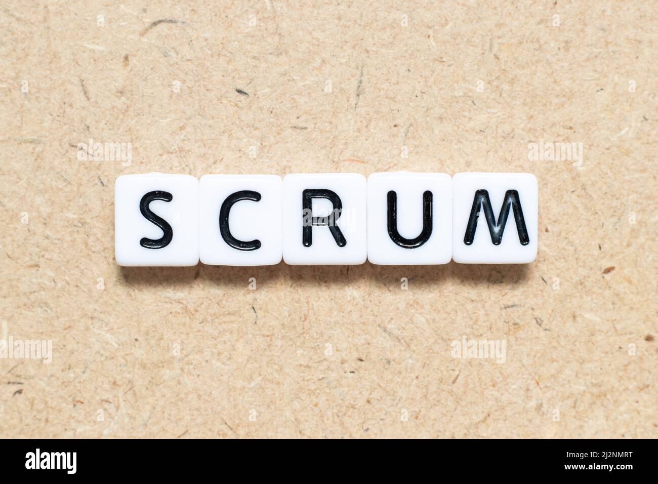 Weißer Kachelbuchstabe mit Wortschrumm auf Holzhintergrund Stockfoto