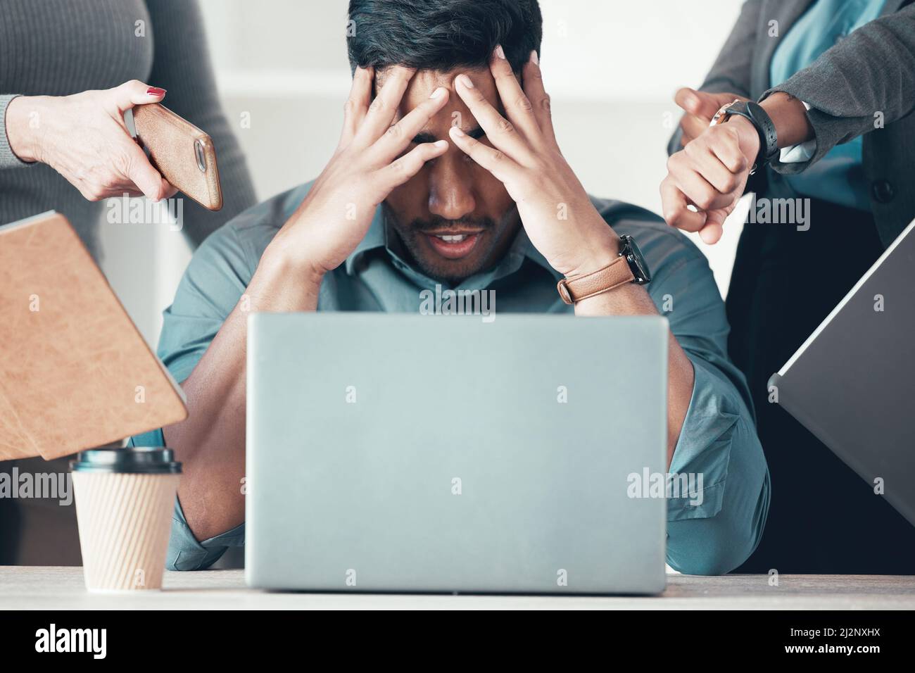 Sie haben mich verrückt gemacht. Aufnahme eines nicht erkennbaren Geschäftsmannes, der im Büro sitzt und sich gestresst fühlt, während seine Kollegen Druck auf ihn ausüben. Stockfoto