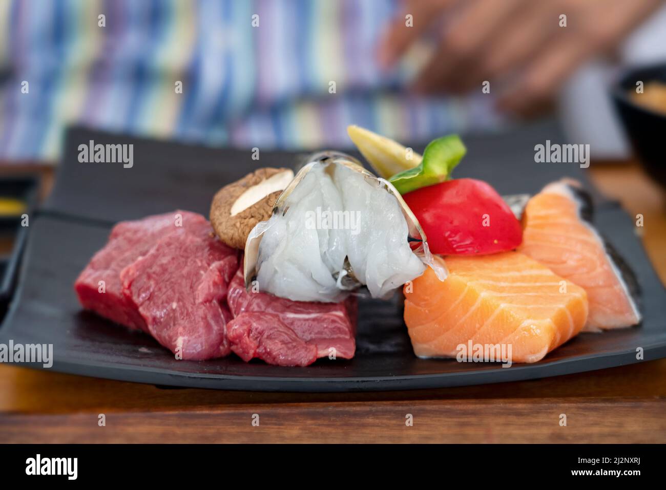 Gegrillte Rindersteaks mit Gewürzen auf HOT Stone mischen. Asiatisches Dinner-Konzept. Dampfendes heißes Steak auf heißem Stein. Stockfoto