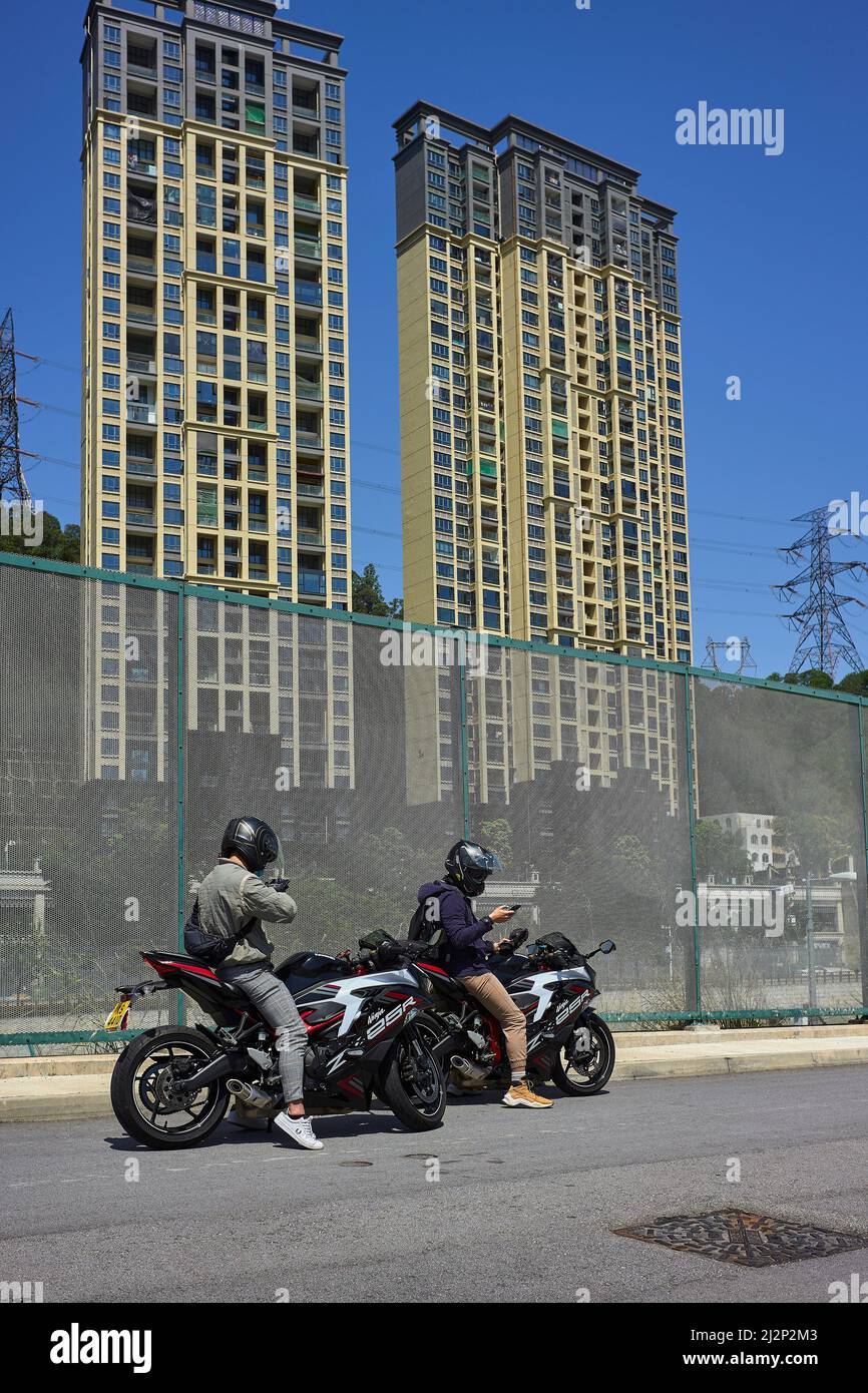 Hongkong, China. 03. April 2022. Zwei Männer auf Motorrädern sprechen mit ihren Verwandten in Shenzhen über den Grenzzaun bei Heung Yuen Wai in Hongkong. An der Grenze zwischen Hongkong und Shenzhen gelegen, ist Hung Yuen Wai einer der Orte, an dem Familien, die aufgrund von Reisebeschränkungen zwischen Covid-19 und der Grenze getrennt sind, einander sehen können. Kredit: SOPA Images Limited/Alamy Live Nachrichten Stockfoto