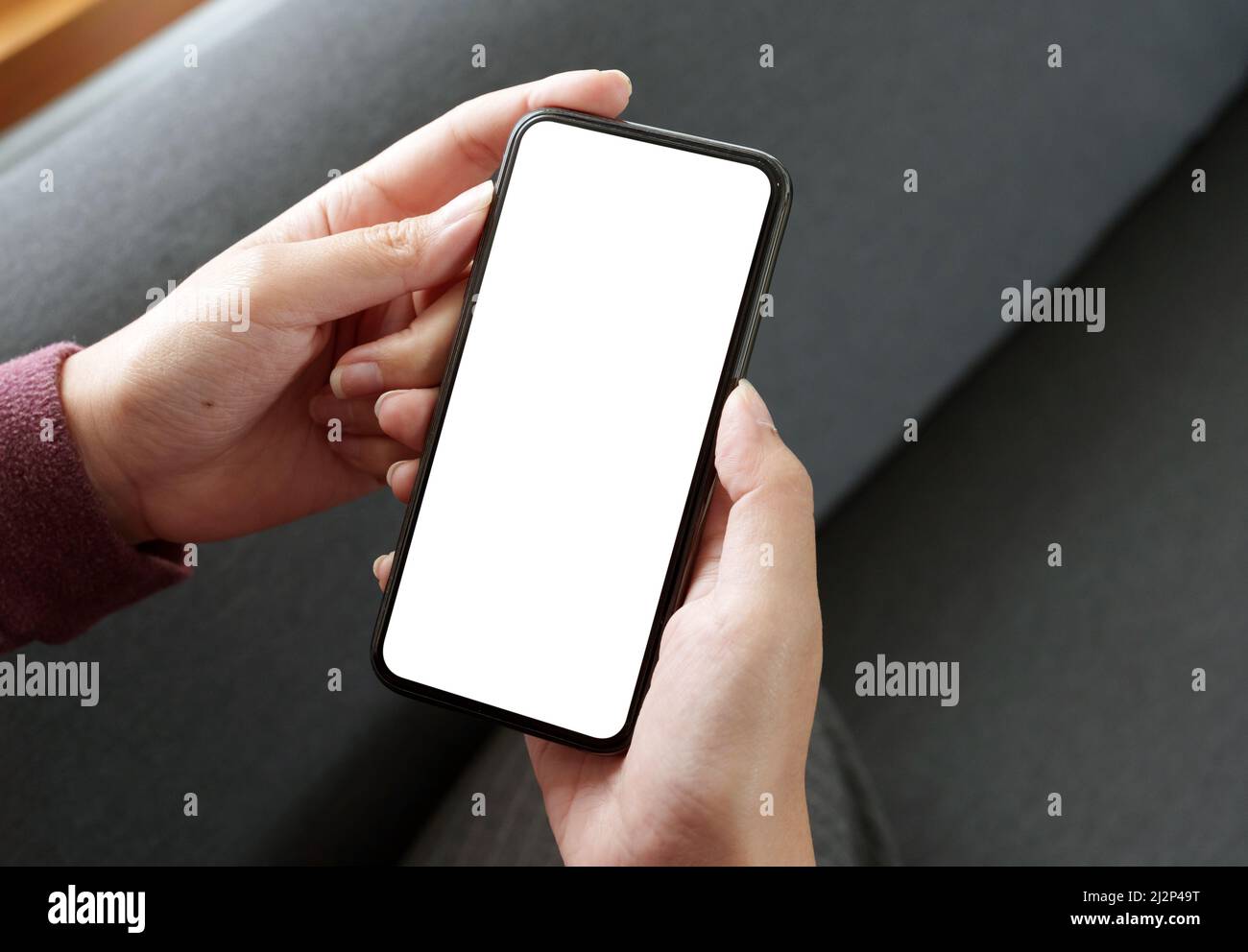 Draufsicht Frau sitzt und hält leere Bildschirm Mock-up-Handy Stockfoto