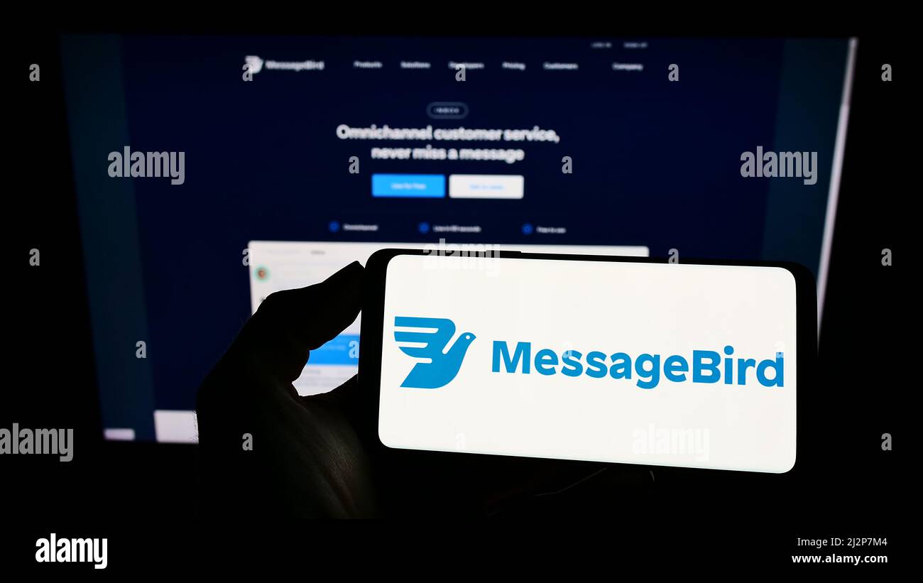 Person, die Mobiltelefon mit dem Logo des niederländischen Kommunikationsunternehmens MessageBird BV auf dem Bildschirm vor der Geschäftswebseite hält. Konzentrieren Sie sich auf die Telefonanzeige. Stockfoto