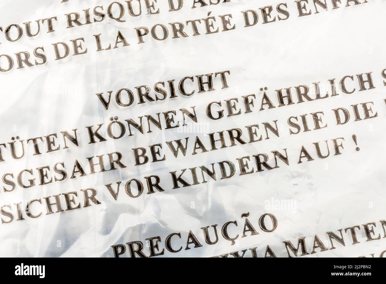 Warnung zur Erstickungsgefahr (Deutsch & mehrsprachig) auf LDPE-/Polyethylenbeutel mit geringer Dichte. Für Kinder-Sicherheitswarnung, Kunststoff-Recycling Stockfoto