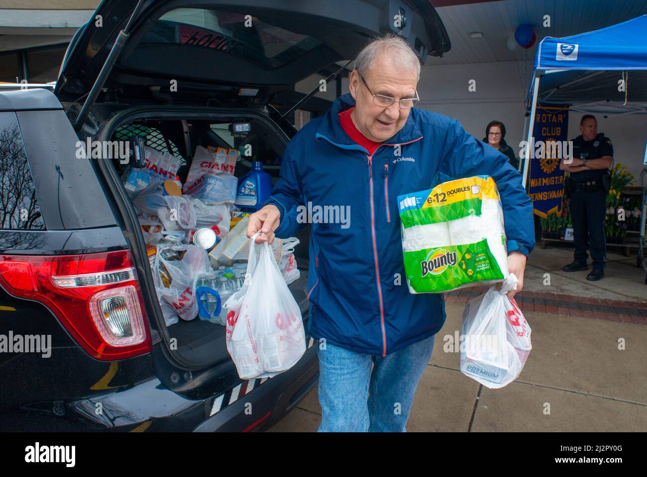 Warminster, Usa. 03. April 2022. Ein Freiwilliger transportiert Gegenstände während einer Food-Fahrt vom Polizeikreuzer in einen Lieferwagen, um die Lebensmittelregale der Warminster Food Bank am Sonntag, den 03. April 2022 in Gant in Warminster, Pennsylvania, aufzufüllen. Über 2300 Pfund Lebensmittel wurden zusammen mit Geschenkkarten und anderen Gegenständen gespendet. (Foto: William Thomas Cain/Alamy Live News Stockfoto
