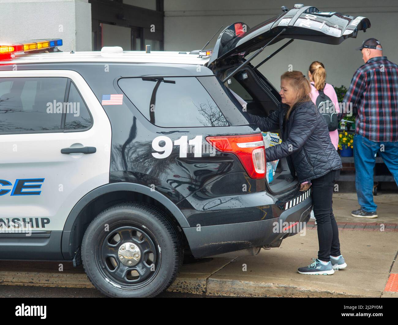 Warminster, Usa. 03. April 2022. Valerie Brown lädt während einer Food-Fahrt Spenden in ein Polizeifahrzeug, um die Lebensmittelregale der Warminster Food Bank am Sonntag, den 03. April 2022 im Giant in Warminster, Pennsylvania, aufzufüllen. Über 2300 Pfund Lebensmittel wurden zusammen mit Geschenkkarten und anderen Gegenständen gespendet. (Foto: William Thomas Cain/Alamy Live News Stockfoto