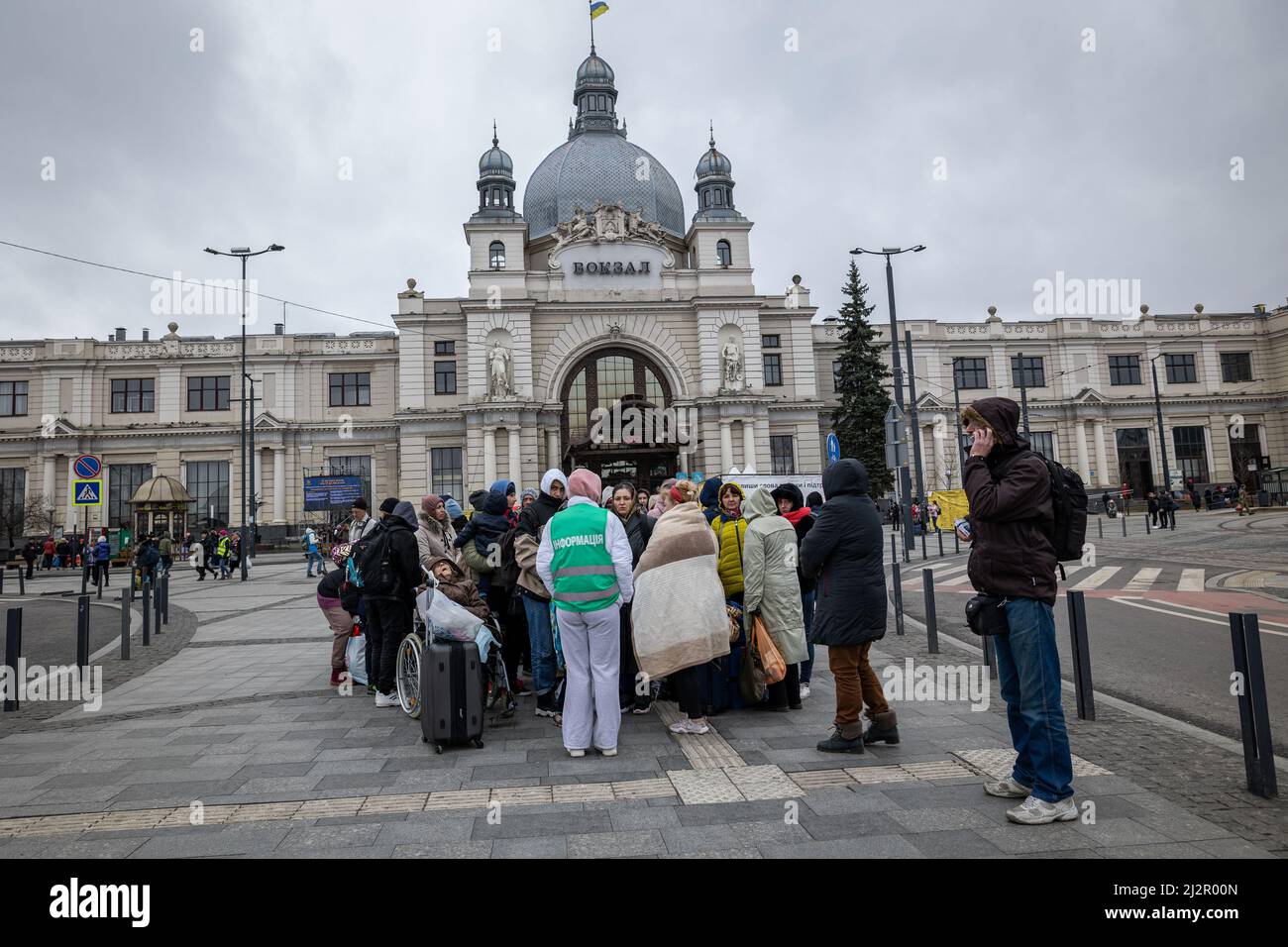 LVIV, UKRAINE - APR 02, 2022: Freiwillige und Flüchtlinge, die gerade mit dem Evakuierungszug aus Kramatorsk angekommen sind, warten auf ihre weitere Busverbindung Stockfoto