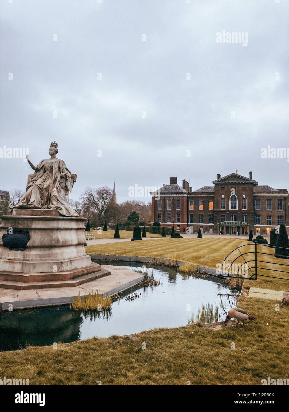 Statue der Königin Victoria vor dem Kensington Palace an einem bewölkten Tag im Hyde Park, London Stockfoto