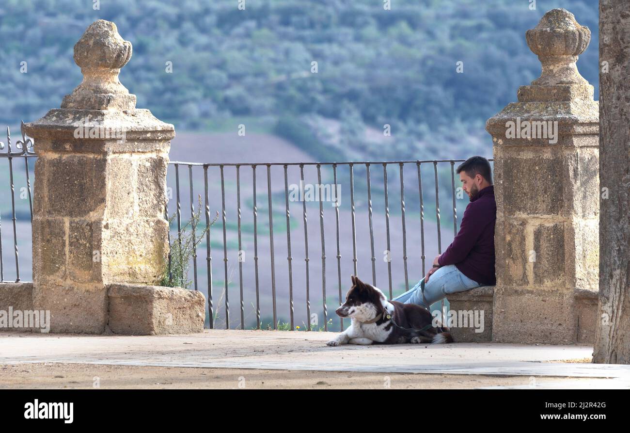 Ein junger Mann sitzt in der Nähe des Aussichtspunkts am Rand der Klippen im Alameda del Tajo Park Ronda Spanien Stockfoto