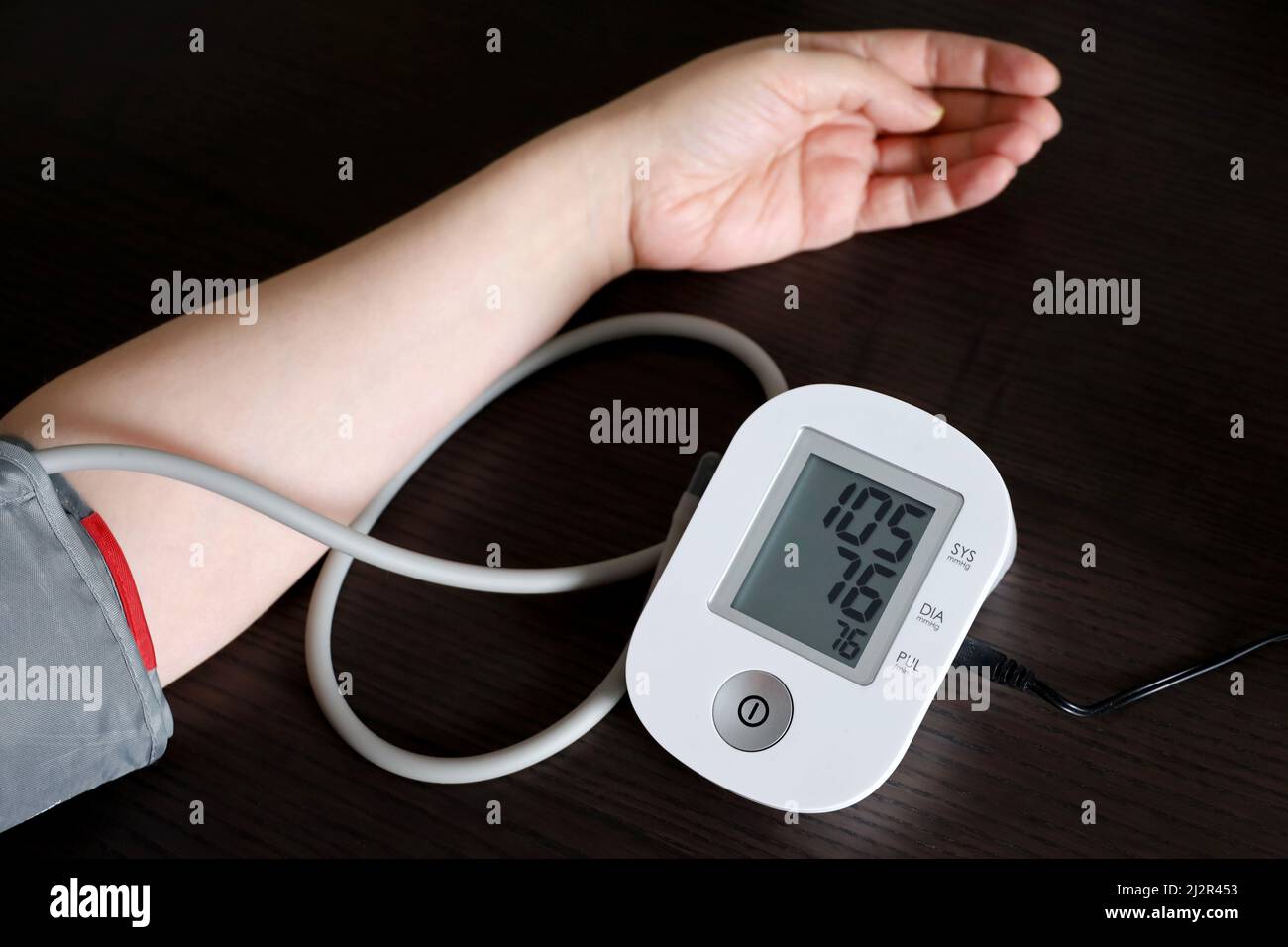 Frau, die den Blutdruck mit elektronischem Digitaltonometer misst, weibliche Hand aus nächster Nähe. Arterielle Hypertonie und kardiologisches Konzept Stockfoto