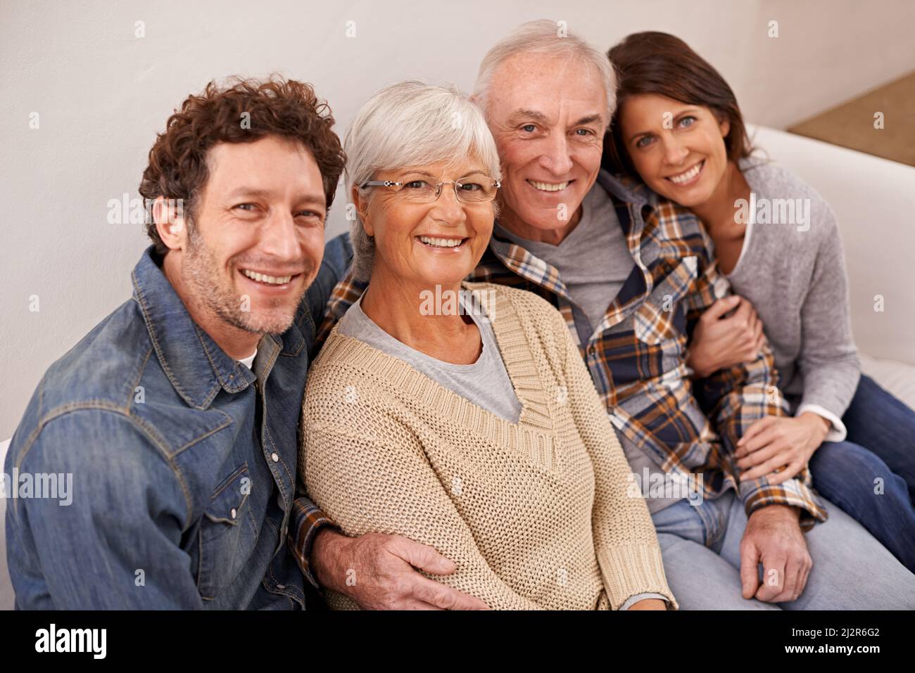 Zeit mit Mama und Papa verbringen. Ein Porträt glücklicher, reifer Eltern, die mit ihren erwachsenen Kindern zu Hause sitzen. Stockfoto