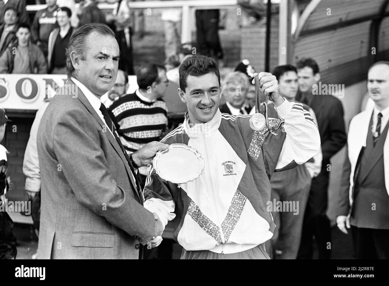 Der britische Radfahrer Chris Boardman auf dem Platz im Prenton Park, dem Heimstadion von Tranmere Rovers, nach seiner Rückkehr von den Olympischen Spielen 1992 in Barcelona, wo er eine Goldmedaille für Großbritannien gewann. Hier zeigt er der Menge die Medaille. 11.. August 1992. Stockfoto