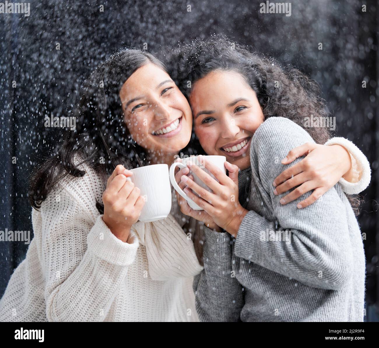 Wer kein Weihnachten im Herzen hat, wird es nie unter einem Baum finden. Aufnahme von zwei jungen Frauen, die draußen im Schnee Kaffee trinken. Stockfoto