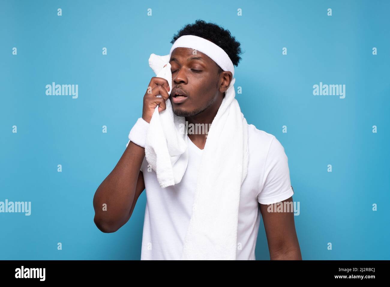 Ruhezeit. Müde afrikaner im Sport tragen müde nach dem Training. Studio auf blauer Wand. Stockfoto