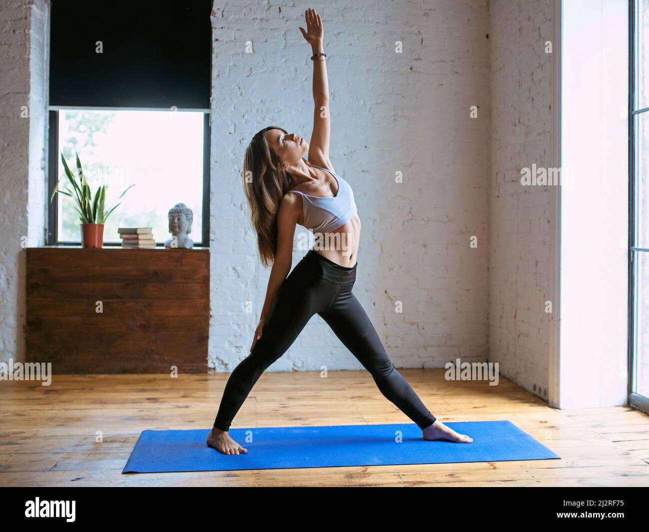 Junge Frau in Sportbekleidung in verschiedenen Yoga-Asanas in Innenräumen. Yoga- und Sportkonzept Stockfoto