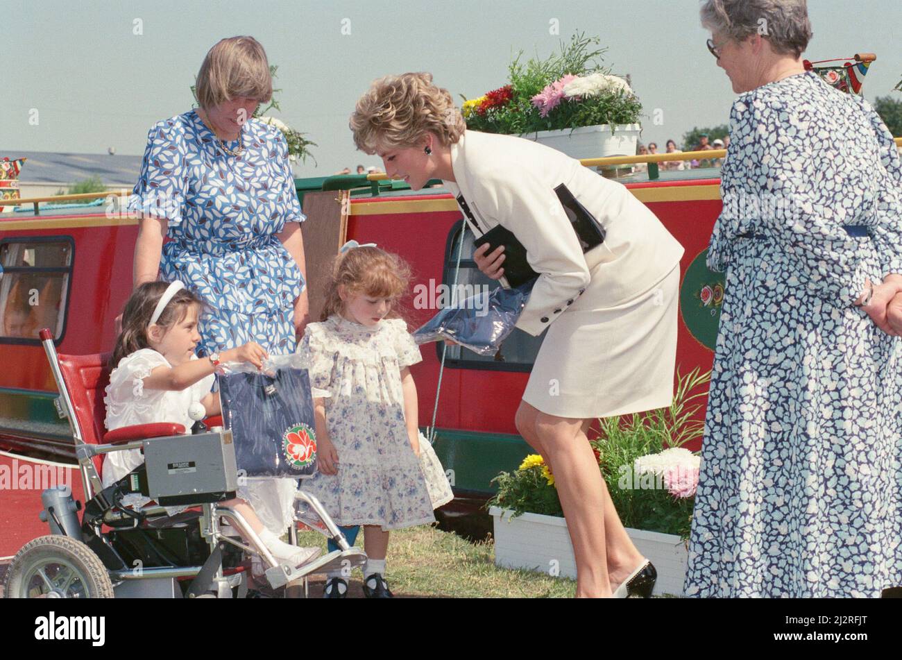 Prinzessin Diana, Prinzessin von Wales, während ihres Besuches in Manchester, England, verlässt den roten Lastkahn im Hintergrund "Prinz William" in Altrincham und trifft viele gute Fischer, die sich herausgestellt haben, um sie zu sehen. Hier trifft sie Caroline Byrne (4) und Seranne Creedy (7), beide von der Pictor School. Während ihres Aufenthalts im Nordwesten besucht sie auch das Manchester Royal Infirmary. Bild aufgenommen am 7.. Juli 1992 Stockfoto