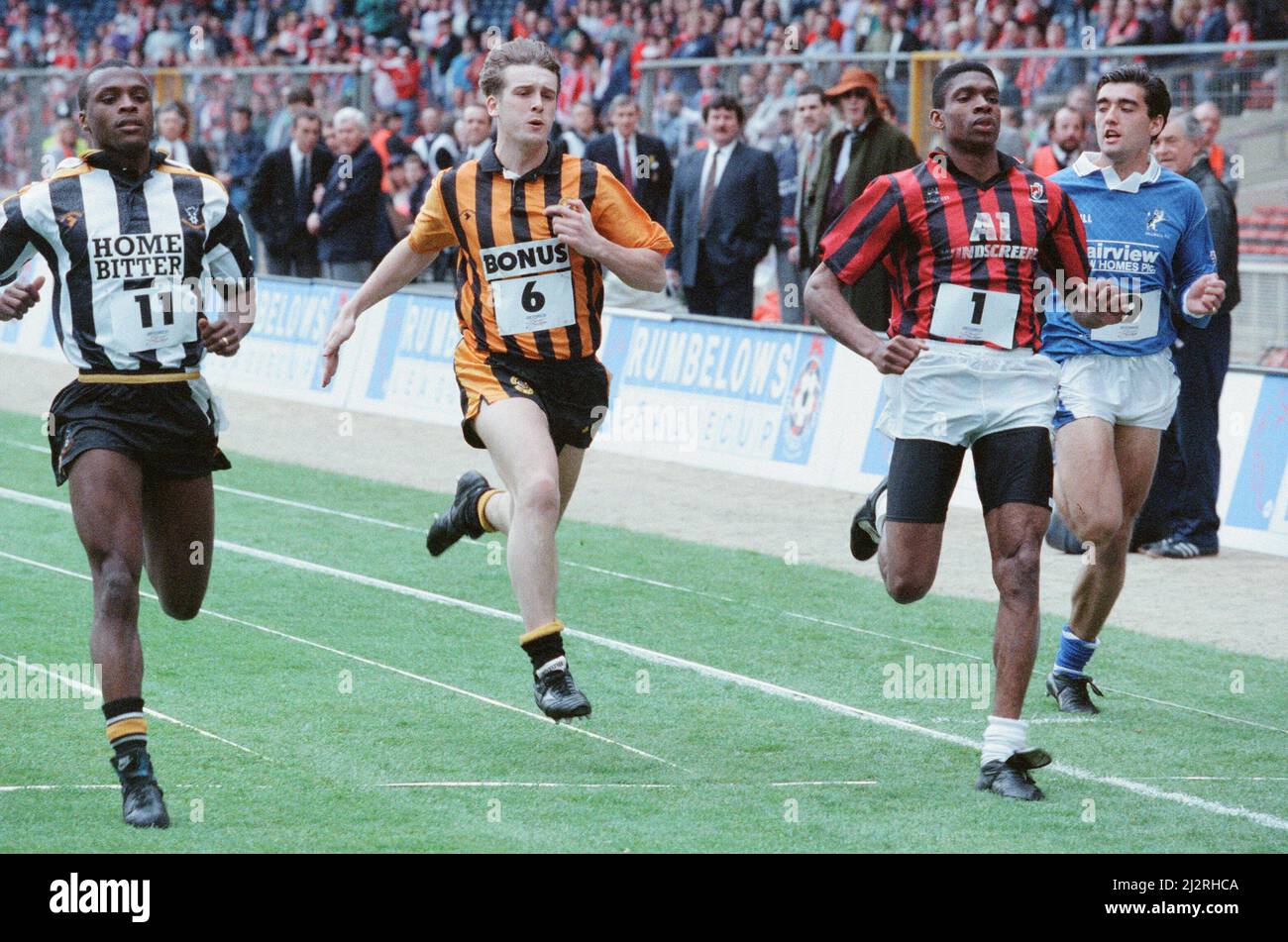 Rumbelows Sprint Challenge 1. Halbfinale, Wembley Stadium, Sonntag, 12.. April 992. Ziel der Challenge war es, den schnellsten Spieler in der Liga zu finden. Jeder Club ist eingeladen, seinen schnellsten Spieler zu regionalen Vorläufen zu schicken, wobei sich die schnellsten 2 Spieler und die schnellsten 4 Verlierer für das Finale qualifizieren. Die Spieler mussten 100m in Fußballschuhen und normalem Matchkit auf Gras laufen. Der Wettbewerb wurde von John Williams von Swansea City gewonnen, der zehntausend Pfund gesammelt hat. Im Bild: Nr. 11 Kevin Bartlett (Notts County), Nr. 6 Leigh Jenkinson (Hull), Nr. 1 Efan Ekoku (Bournemouth) Stockfoto