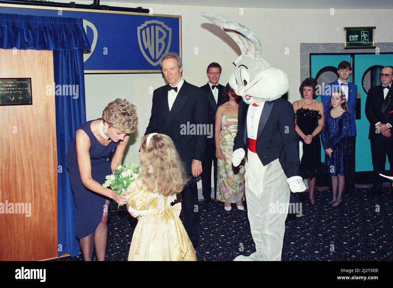 Prinzessin Diana, die Prinzessin von Wales, im neuen Warner West End Kino im Leicester Square London, zur Premiere von The Fugitive. Diana wird von einem jungen Mädchen mit einigen Blumen überreicht, während Clint Eastwood und jemand in einem Bugs Bunny Kostüm den Moment ebenfalls genießen. Bild aufgenommen am 23.. September 1993 Stockfoto