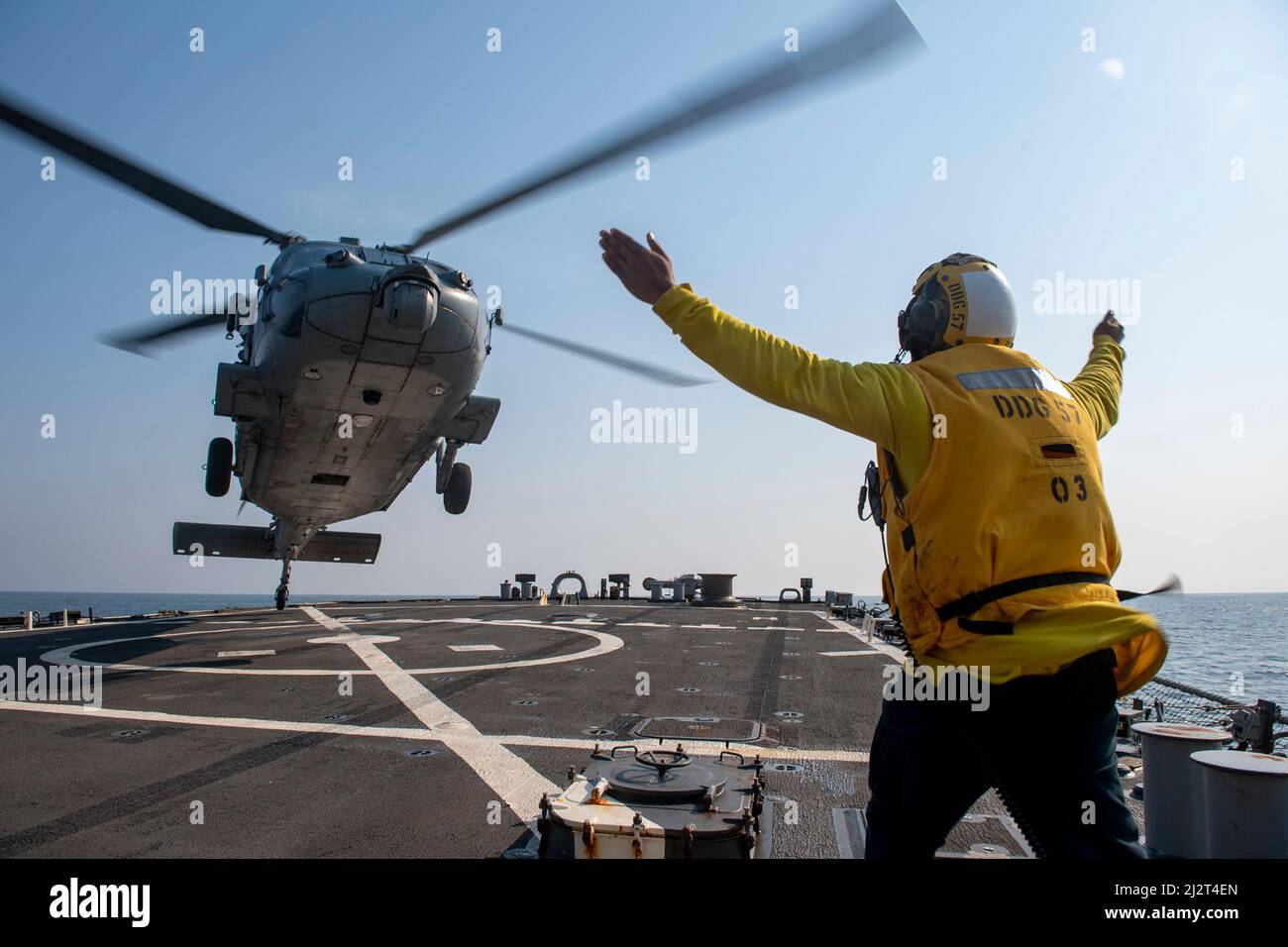 220326-N-HG846-1075 ÄGÄISCHES MEER (26. März 2022) – Boatswains Mate 3. Klasse Tra’shaun Cooper aus Homestead, Texas, leitet einen Hubschrauber MH-60s Sea Hawk, der den „Dragoslayers“ des Helicopter Sea Combat Squadron (HSC) 11 zugewiesen wurde, um während des Flugbetriebs an Bord des Lenkraketen-Zerstörers USS Mitscher der Arleigh Burke-Klasse (DDG 57) am 26. März 2022 zu landen. Mitscher wird derzeit bei der Harry S. Truman Carrier Strike Group im US-Einsatzgebiet der Sechsten Flotte eingesetzt, um die Interessen der USA, der Alliierten und der Partner in Europa und Afrika zu unterstützen. (USA Navy Foto von Mass Communication Specialist 2. Stockfoto